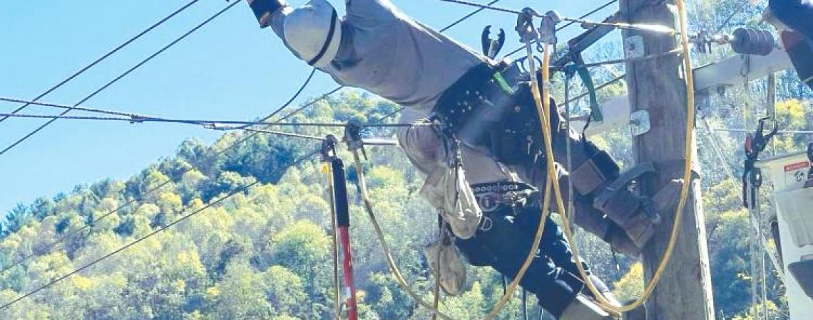 Max Noll, who works for South Central Power Company in Lancaster, stretches as he works to make repairs on lines near Boone, North Carolina. Noll was one of more than 100 Ohio co-op lineworkers who answered the call for help.