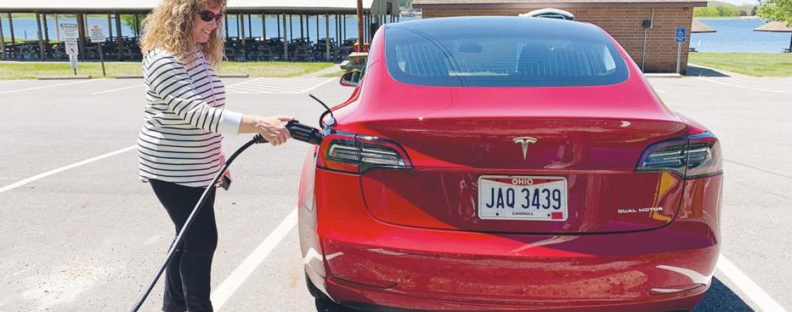 A woman charging her electric vehicle