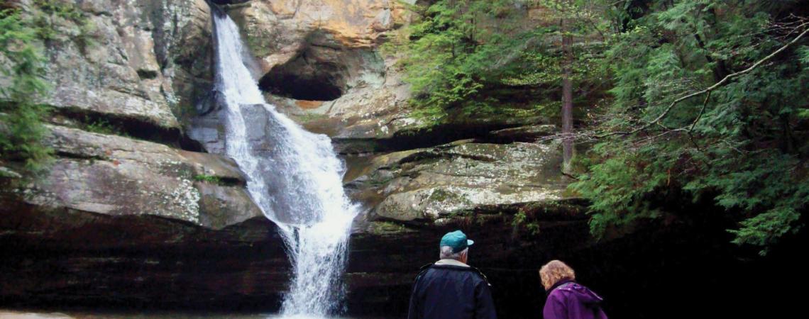 A couple looking at a waterfall in the woods