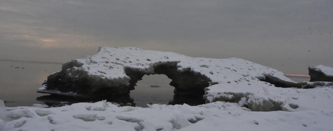 Remnants of Lake Erie’s ice hang on as late as March, with wind, waves, and warming water developing arches and caves along the shoreline.
