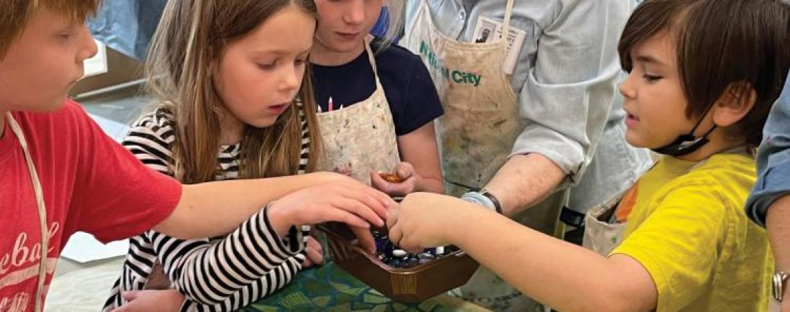 A woman teaching children in an art class