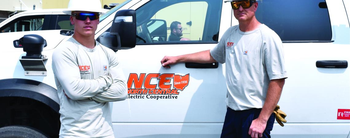 modern lineworkers in front of NCE truck