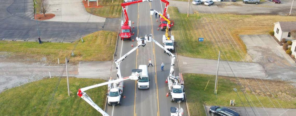 An arch made with bucket trucks over a funeral procession