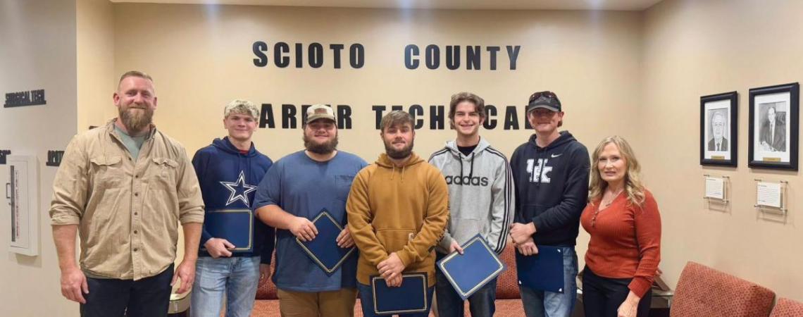 A group of people accepting a scholarship donation