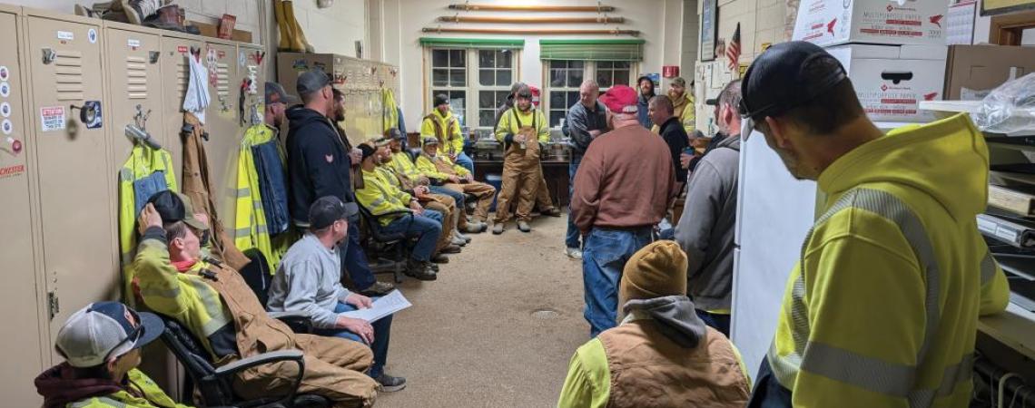 A group of lineworkers having a team meeting