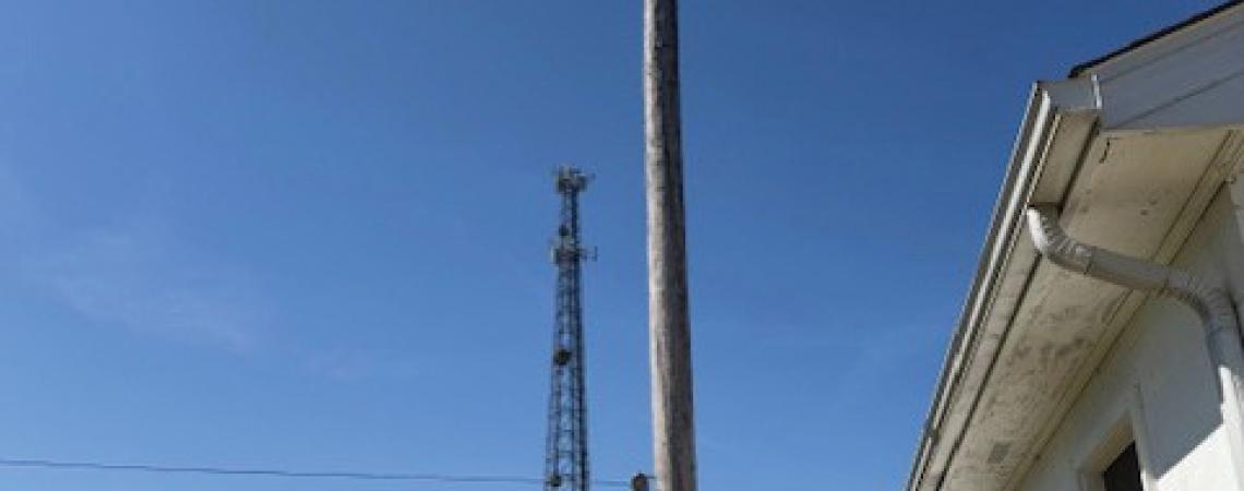 A young boy looking at a utility pole