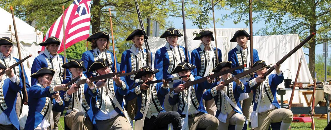 Middle school students participating in a Revolutionary War reenactment
