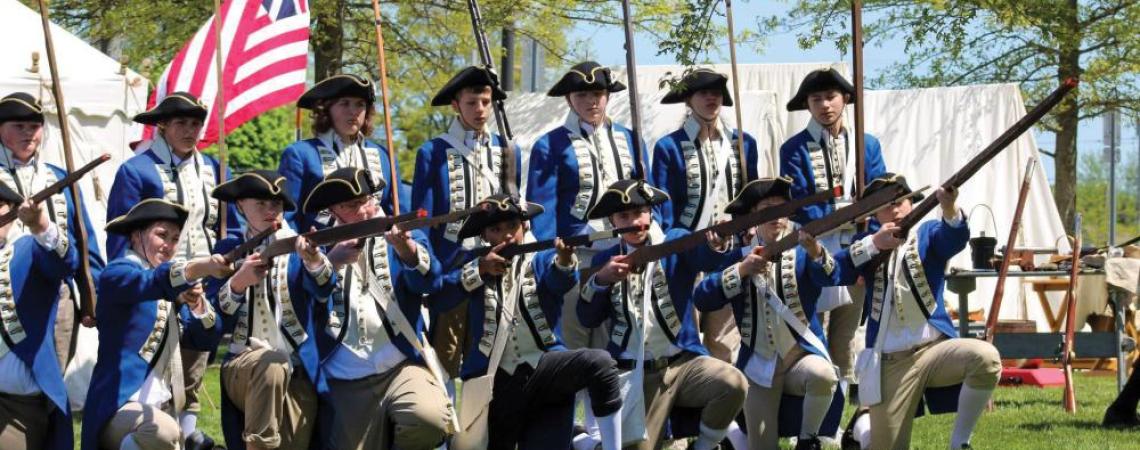 A group of students doing a Revolutionary War reenactment