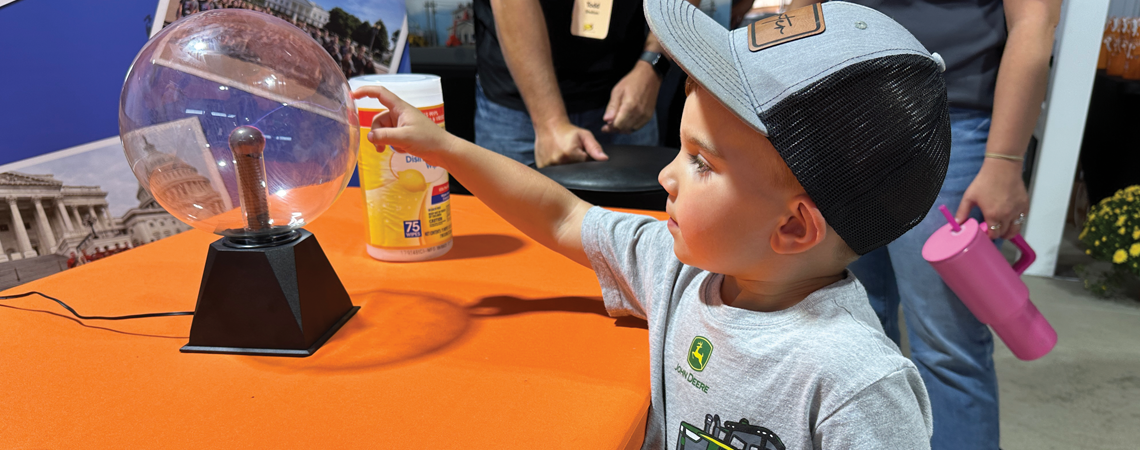 A little boy playing with an electric globe on a table