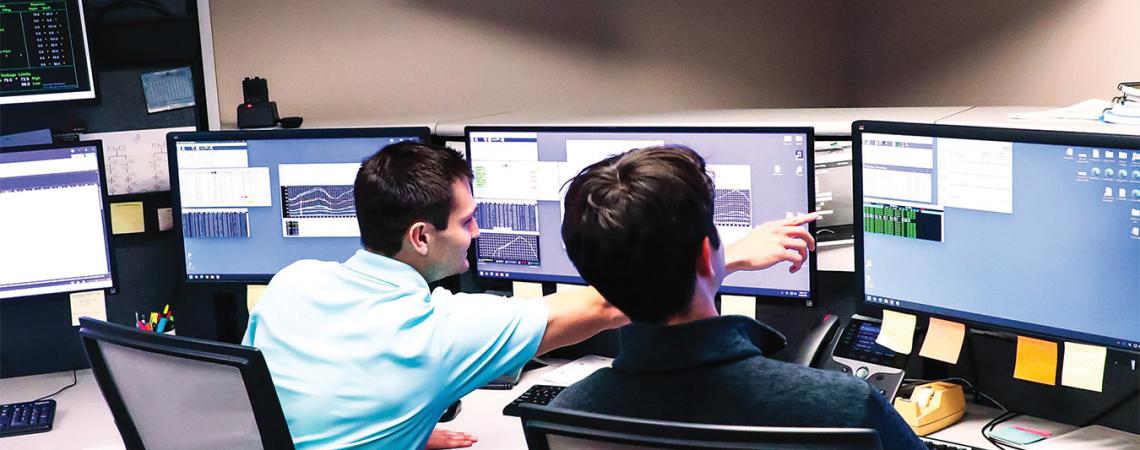 Two employees working in a control room