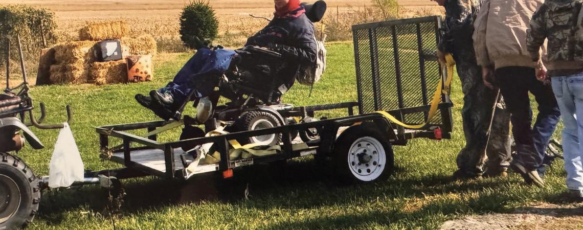 A veteran in a motor scooter on a trailer