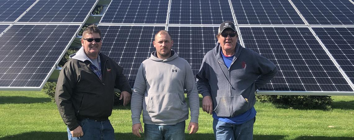 Tietje family in front of solar panels